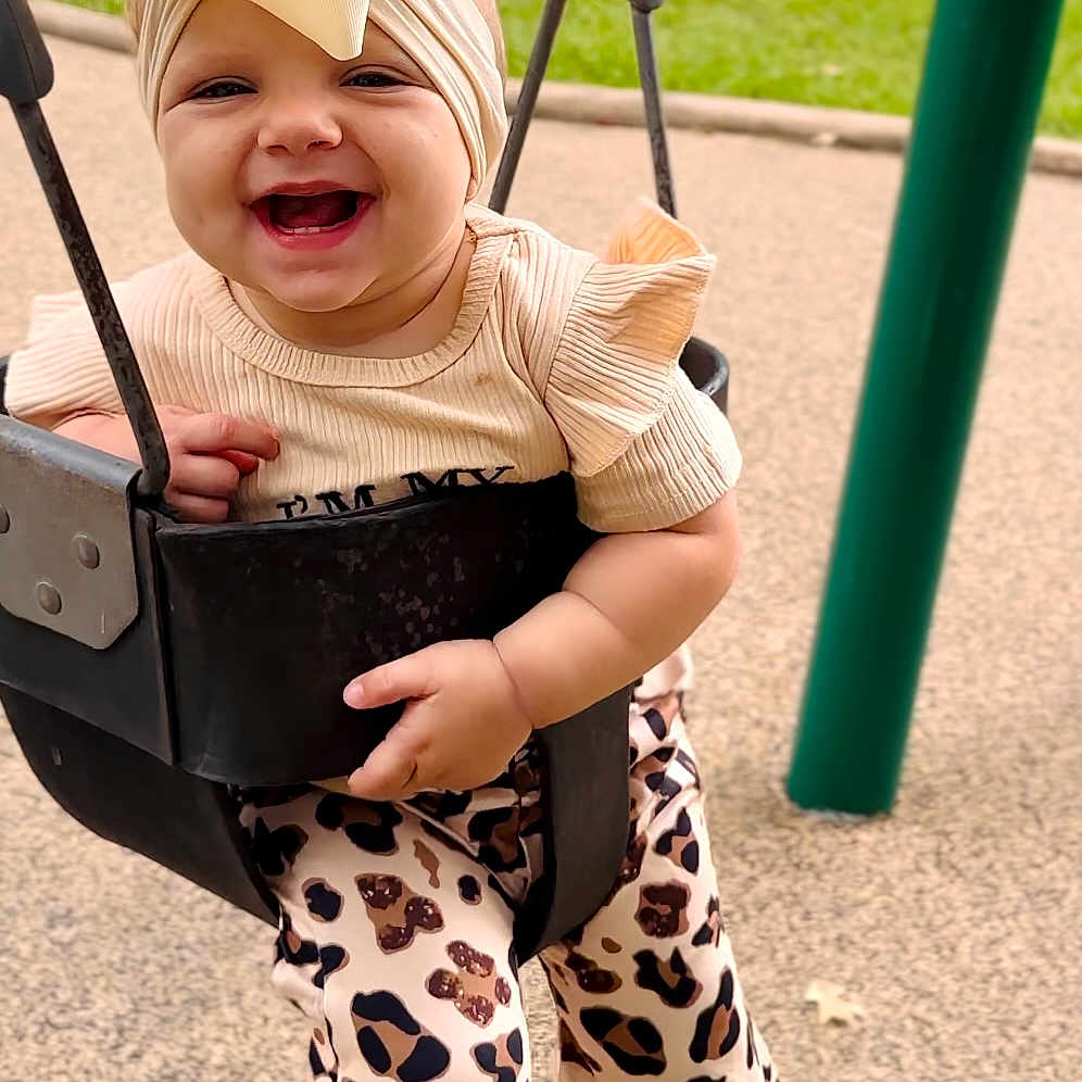 Hannah is registered to the contest to win money with this photo: baby, babylaughing, clothing, dress, face, grass, happy, hat, head, nature, outdoorplayarea, outdoors, pants, park, person, photography, plant, playarea, portrait, toy