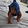 baby, child, crawling, blue_hood, bed, bedroom, pillow, blanket, infant, cute, curious, person, indoors, furniture, headwear, playful, skin, young_child, expression, clothing