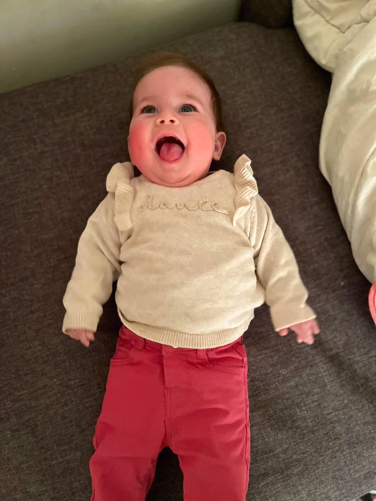Alessia participe au concours pour gagner de l'argent avec cette photo : arm, baby, baby_toddler_clothing, cheek, comfort, eye, face, flooring, fun, gesture, happy, head, human_body, neck, nose, person, skin, sleeve, smile, t_shirt