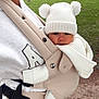 baby, child, adult, baby_carrier, knit_hat, pom_poms, knit_sweater, outdoor, grass, trees, person, nature, walk, park, white_clothing, beige_carrier, close_up, face, warm_clothing, casual_wear