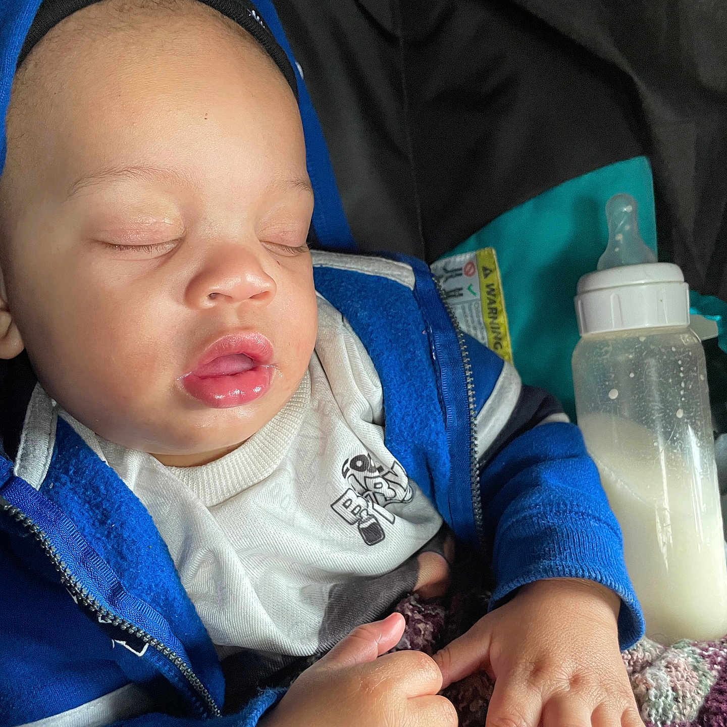 Dashaun joined the competition — help win amazing prizes! baby, beverage, bodypart, clothing, coat, face, finger, hand, head, hoodie, jacket, knitwear, milk, newborn, person, photography, portrait, sleeping, sweater, sweatshirt