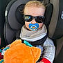 baby, car_interior, car_seat, casual, child, clothing, comfort, cute, hands, headrest, infant, pacifier, plush_toy, portrait, safety, seat_belt, sunglasses, toy, travel, young_child