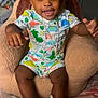 Dekhari joined the competition — help win amazing prizes! toddler, child, smiling, sitting, indoor, chair, plush, clothing, dinosaur_pattern, sneakers, necklace, happy, person, footwear, cute, baby, expression, head, face, furniture