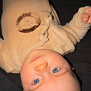 Sohan participe au concours pour gagner de l'argent avec cette photo : baby, infant, blue_eyes, onesie, lion_patch, sleepwear, laying_down, portrait, close_up, face, cheeks, blanket, bed, indoor, cute, pale_skin, light_hair, gaze, hand, soft_fabric