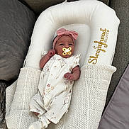 Mila is registered to the contest to win money with this photo: baby, infant, pacifier, headband, pink_bow, sleepyhead_deluxe, blanket, couch, soft_fabric, white_clothing, floral_pattern, socks, newborn, resting, indoors, cozy, comfort, child, cute, portrait