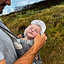 baby, sleeping, carrier, adult, hat, outdoor, grass, field, clouds, nature, person, portrait, closeup, hand, face, resting, parent, holding, summer, relaxation