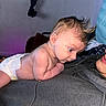 Hudson joined the competition — help win amazing prizes! baby, infant, diaper, person, face, hair, curious, indoors, lying_down, skin, head, baby_hair, expression, human, clothing, adult, hoodie, portrait, closeup, interaction