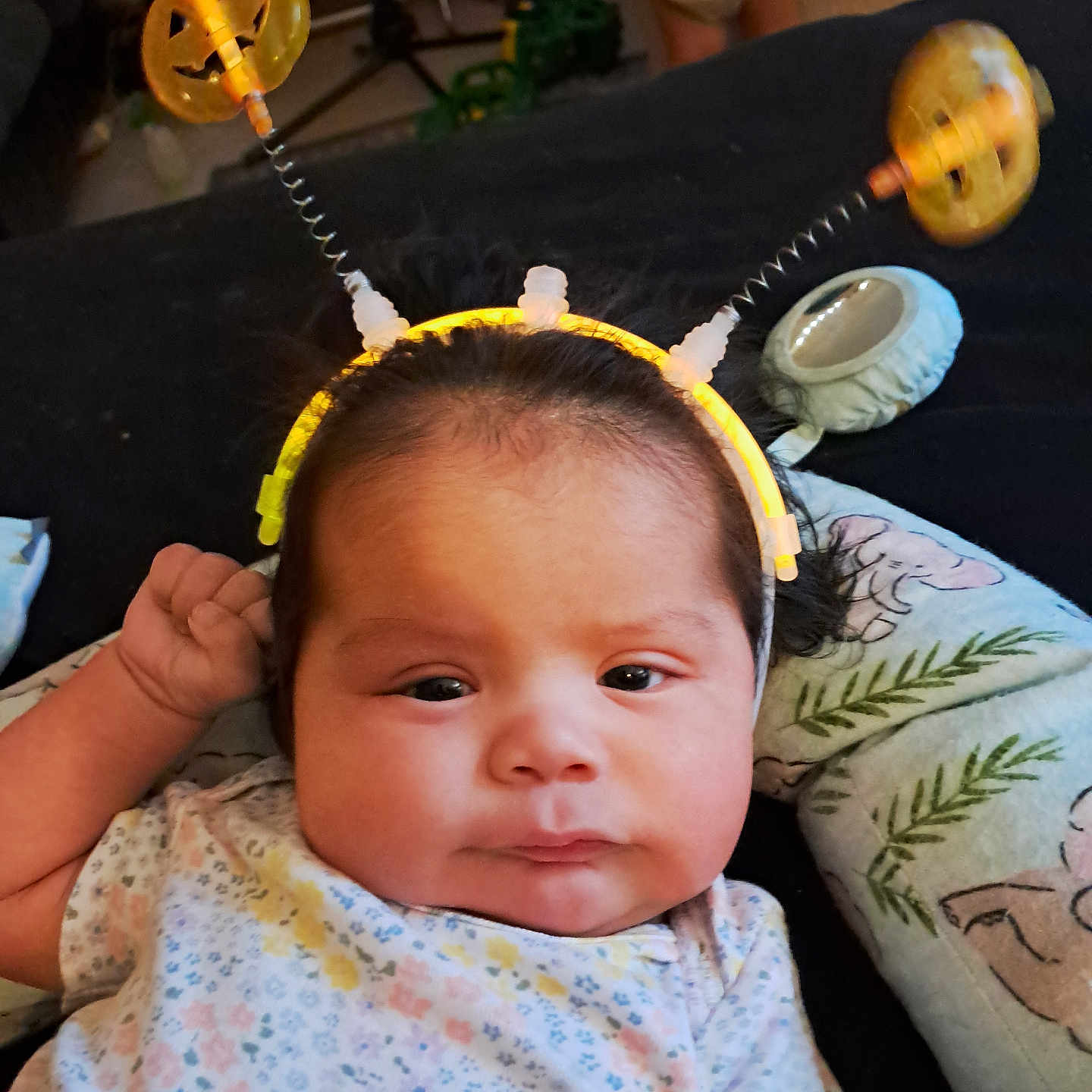 Macrista joined the competition — help win amazing prizes! baby, black_hair, child, clothing, cute, expression, face, floral_pattern, glowing, halloween, hand, headband, indoors, infant, lying_down, person, pillow, pumpkin, soft_lighting, young