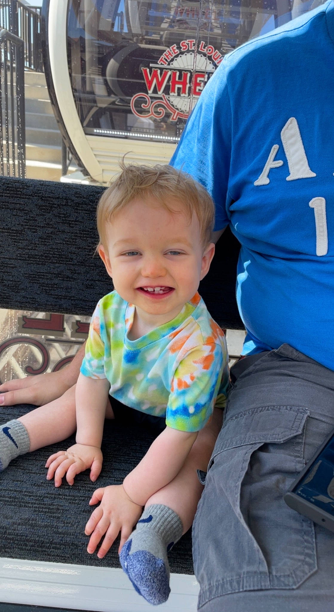 Greysen is registered to the contest to win money with this photo: baby, baby_toddler_clothing, child, electric_blue, fun, grass, happy, joy, leisure, logo, people, person, play, recreation, sitting, sleeve, smile, t_shirt, toddler, vacation