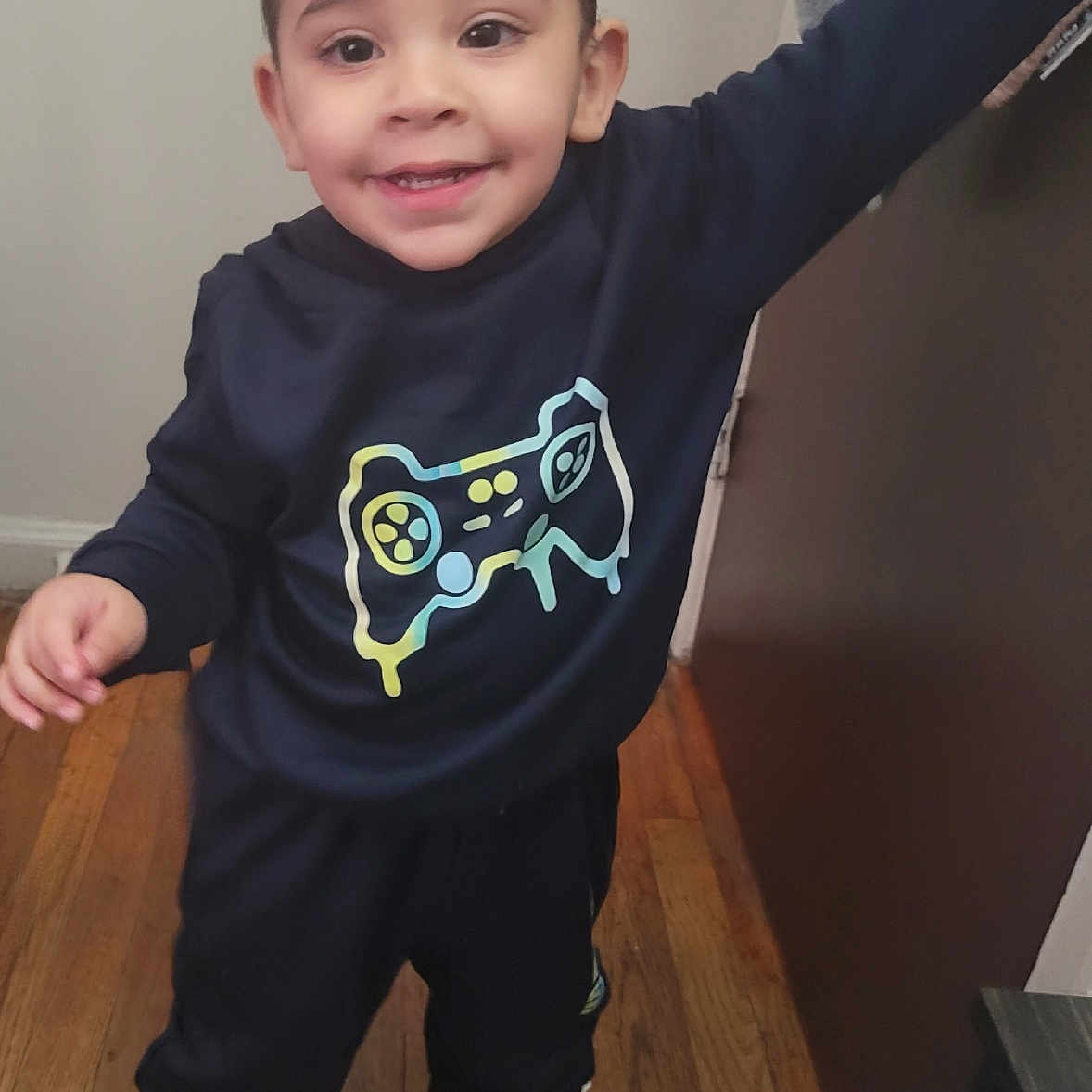 Damien is registered to the contest to win money with this photo: boy, child, clothing, face, footwear, hardwood, head, jeans, longsleeve, male, pants, person, photography, portrait, runningshoe, shoe, sleeve, sneaker, t_shirt, wood