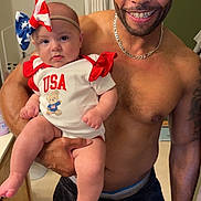Riella is registered to the contest to win money with this photo: baby, bathroom, blue, bow, casual, child, family, headband, holding, indoor, man, patriotic, person, portrait, red, shirtless, smile, toddler, usa, white