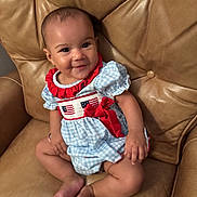 Layla joined the competition — help win amazing prizes! baby, child, smile, portrait, leather_chair, blue_dress, red_ribbon, american_flag, cute, happy, sitting, infant, furniture, indoor, person, young_child, skin, head, legs, arm