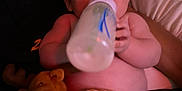 Knox is registered to the contest to win money with this photo: adult, baby, blanket, bottle, care, child, closeup, comfort, cuddle, expression, face, feeding, holding, indoor, person, plush_toy, relaxation, skin, sleepy, soft_light