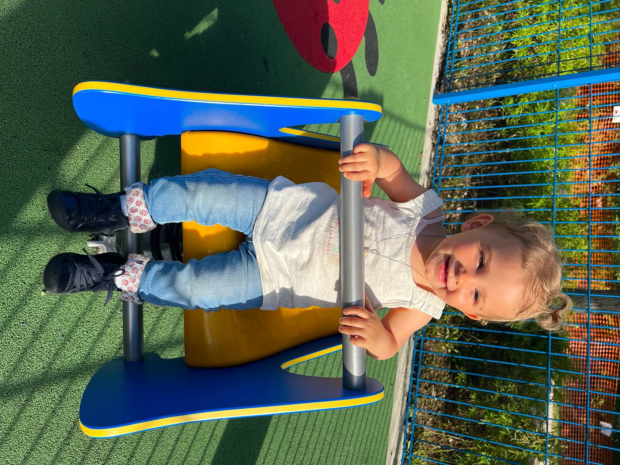 Léana participe au concours pour gagner de l'argent avec cette photo : child, electric_blue, fun, grass, green, human_leg, joy, knee, leisure, mesh, net, outdoor_play_equipment, person, play, player, playground, recreation, shorts, sports, toddler