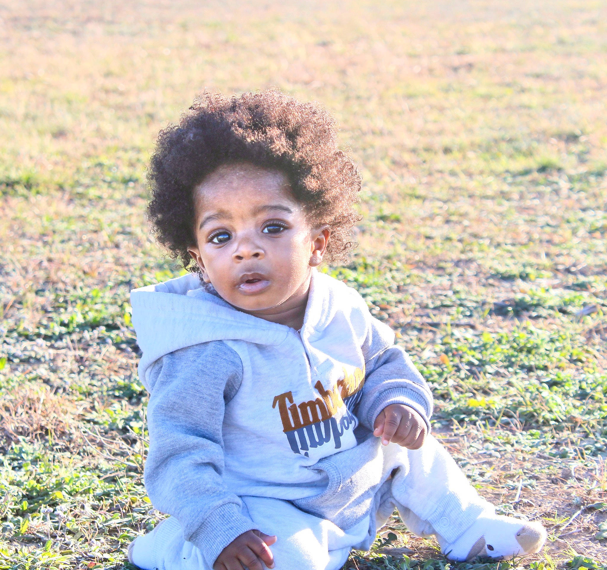 Nate is registered to the contest to win money with this photo: afro, baby_toddler_clothing, child, field, flash_photography, fun, grass, grass_family, grassland, happy, landscape, leisure, people, people_in_nature, person, portrait, portrait_photography, sitting, soil, sunlight