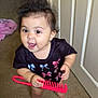 baby, child, barefoot, carpet, comb, door, floor, hair, indoors, person, shirt, smiling, standing, toy, young_child, playful, happy, colorful_clothing, pink, black_shirt