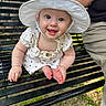 baby, child, smiling, white_hat, polka_dot_dress, bench, outdoor, grass, happy, person, face, headwear, summer, cute, sitting, portrait, daylight, skin, arm, legs