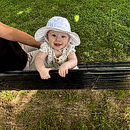Harley joined the competition — help win amazing prizes! baby, child, hat, white_clothing, polka_dot, bench, black_bench, grass, park, outdoor, sunlight, smiling, happy, person, arm, nature, daylight, cute, infant, support