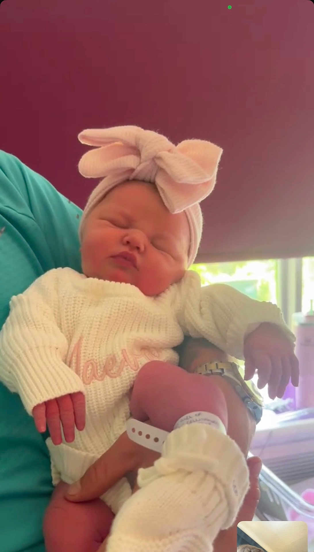 Maeva is registered to the contest to win money with this photo: newborn, baby, infant, sleeping, headband, bow, knitwear, sweater, sock, hand, person, holding, indoor, soft_light, portrait, cute, peaceful, closeup, hospital_band, cozy