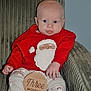 Jimmy is registered to the contest to win money with this photo: baby, infant, child, red_clothing, santa_clothing, wooden_sign, three_months, chair, green_chair, holiday_theme, cute, sitting, portrait, indoors, feet, hands, face, milestone, smiling, young_child