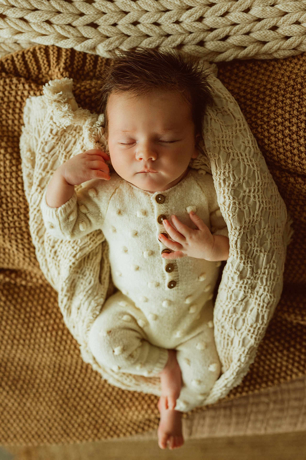Jett joined the competition — help win amazing prizes! baby, sleeping, blanket, knitted, onesie, buttoned_clothing, infant, peaceful, cozy, texture, brown, cream, cute, resting, hand, foot, portrait, soft_lighting, indoors, closeup