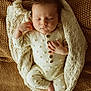 Jett is registered to the contest to win money with this photo: baby, sleeping, blanket, knitted, onesie, buttoned_clothing, infant, peaceful, cozy, texture, brown, cream, cute, resting, hand, foot, portrait, soft_lighting, indoors, closeup