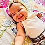 Israa a rejoint le concours — aidez-le/la à gagner de superbes lots ! arm, baby, cheeks, child, closeup, clothing, colorful, cute, expression, floral_blanket, happy, headband, indoors, infant, lying_down, patterned_pants, person, portrait, skin, smiling