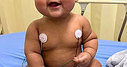 Aliyah joined the competition — help win amazing prizes! baby, child, chubby_cheeks, cute, cute_expression, diaper, electrodes, happy, healthcare, hospital_bed, indoors, infant, medical, monitoring, person, sitting, skin, smiling, socks, young_child