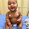 baby, infant, smiling, sitting, medical, electrodes, hospital_bed, diaper, socks, cute, child, healthcare, monitoring, chubby_cheeks, happy, indoors, person, skin, cute_expression, young_child