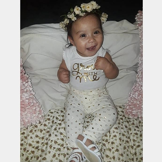 Elia Marie is registered to the contest to win money with this photo: baby, baby_products, baby_toddler_clothing, child, clothing, dress, hair_accessory, happy, head, headgear, headpiece, joy, person, product, sleeve, smile, toddler, white
