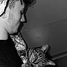 Simba a rejoint le concours — aidez-le/la à gagner de superbes lots ! black_and_white, blanket, cat, close_up, comfort, curly_hair, face, gentle, holding, indoor, person, pet, quiet, side_profile, sleepy, tabby_cat, tattoo, tender_moment, wall, young_man