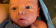 Stetson is registered to the contest to win money with this photo: baby, child, closeup, cozy, curious, expression, eyes, face, fingers, head, indoor, infant, newborn, person, portrait, skin, soft, towel, warm, wrapped