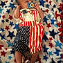 baby, blanket, blue, clothing, comfort, cute, fabric, infant, laying_down, newborn, pacifier, pattern, person, red, sleepwear, small, stars, stripes, toddler, white