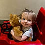 child, childhood, comfort, cute, eyes, face, fun, hair, hug, indoor, person, play, plush_toy, red, seat, short_sleeve_shirt, smile, teddy_bear, toddler, toy_car