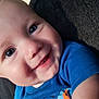Raylan is registered to the contest to win money with this photo: baby, child, smiling, blue_shirt, closeup, face, eyes, cheeks, infant, cute, person, portrait, happy, sitting, indoor, skin, arm, text_on_clothing, casual, young