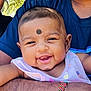 baby, smiling, face, child, person, happy, infant, arm, clothing, skin, portrait, cute, young, mark_on_forehead, sleeveless, outdoor, holding, closeup, expression, joyful