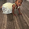 toddler, child, yellow_dress, headband, crawling, smiling, indoor, wooden_floor, happy, baby, person, cute, young_child, flooring, playful, small_child, head, skin_tone, hands, eyes