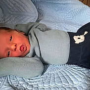 Ezra joined the competition — help win amazing prizes! newborn, baby, infant, blue_sweater, quilt, textured_blanket, lying_down, relaxed_pose, arms_up, face, mouth_open, indoors, soft_texture, cozy, sleepwear, head, person, child, resting, comfortable