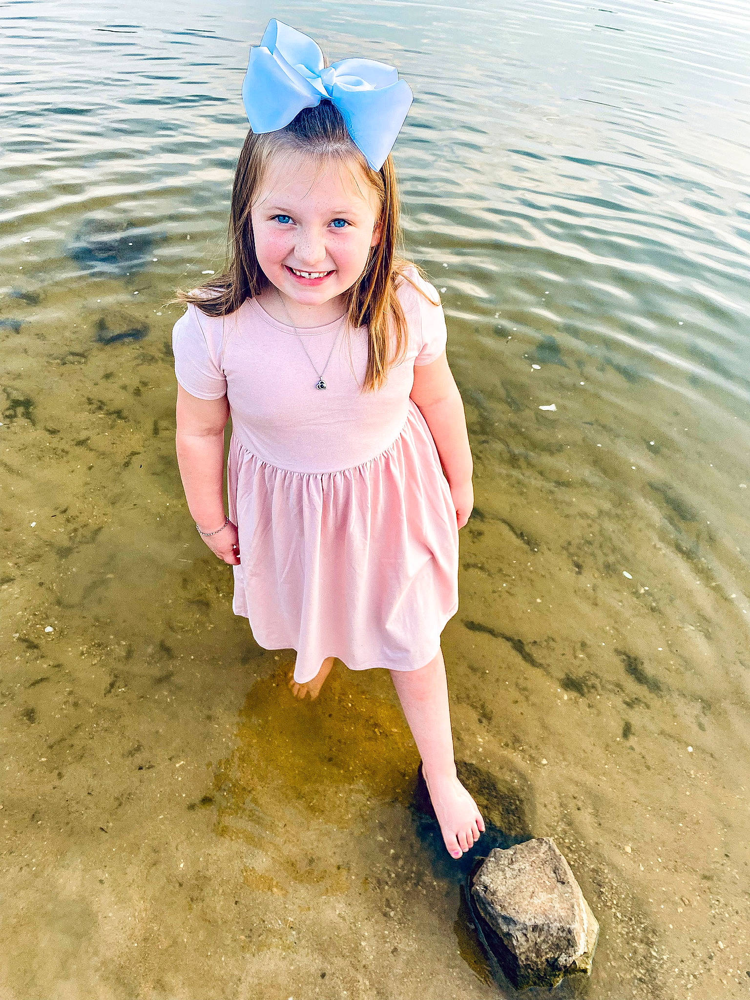 Charlee is registered to the contest to win money with this photo: baby_toddler_clothing, beach, beauty, blond, body_of_water, child, fun, happy, hat, joy, lake, people_in_nature, person, pink, sand, sleeve, smile, summer, sunlight, toddler