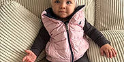 Victoire participe au concours pour gagner de l'argent avec cette photo : baby, blue_eyes, child, clothing, couch, cozy, cute, expression, footwear, hands, headband, indoor, infant, pillows, pink_bow, pink_vest, portrait, seated, textured_fabric, white_sneakers