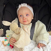 Victoire a rejoint le concours — aidez-le/la à gagner de superbes lots ! baby, blue_eyes, headband, stroller, toy, bunny, blanket, hand, clothing, warm, cute, child, infant, teething_ring, soft, comfort, portrait, indoor, seatbelt, expression