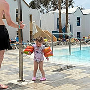 Harlo joined the competition — help win amazing prizes! child, girl, pool, water, floaties, swimsuit, summer, outdoor, sunlight, palm_trees, man, thumbs_up, tiles, vacation, resort, people, relaxing, sunglasses, fun, splash