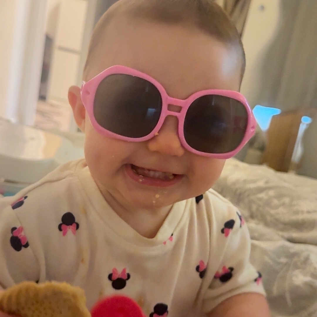Alora-Mae joined the competition — help win amazing prizes! baby, bed, biscuit, child, clothing, cute, diaper, face, happy, home, indoor, infant, person, pink, playful, sitting, smiling, sunglasses, toddler, toy