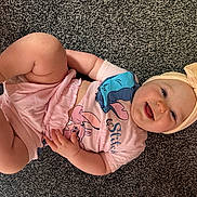 Alora-Mae joined the competition — help win amazing prizes! baby, infant, child, headband, bow, pink_clothing, cartoon_character, smiling, happy, lying_down, carpet, hand, foot, cute, indoors, skin, cheeks, tongue, short_sleeves, playful