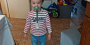 Timaé participe au concours pour gagner de l'argent avec cette photo : toddler, child, indoor, floor, tile, shirt, striped_clothing, jeans, shoes, pacifier, toy, furniture, window, door, heater, box, table, shadow, person, home