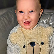 Elouann a rejoint le concours — aidez-le/la à gagner de superbes lots ! applique, baby, babylaughing, clothing, couch, cushion, face, furniture, happy, head, homedecor, knitwear, laughing, pattern, person, photography, portrait, sitting, smile, sweater