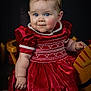 baby, blue_eyes, bracelet, child, cute, dress, earrings, face, happy, indoor, infant, pearl_necklace, photography, portrait, puffed_sleeves, red_dress, sitting, smile, studio, wooden_chair