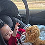 Nalo joined the competition — help win amazing prizes! baby, infant, child, car_seat, seat_belt, teddy_bear, stuffed_animal, blanket, red_clothing, pacifier, hand, reaching, window, trees, car_interior, portrait, cozy, soft_toy, playtime, seat_handle