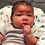 Domani is registered to the contest to win money with this photo: baby, infant, child, face, hand, blanket, clothing, portrait, cute, curious, indoors, soft, cozy, closeup, skin, eyebrows, expression, newborn, person, sitting