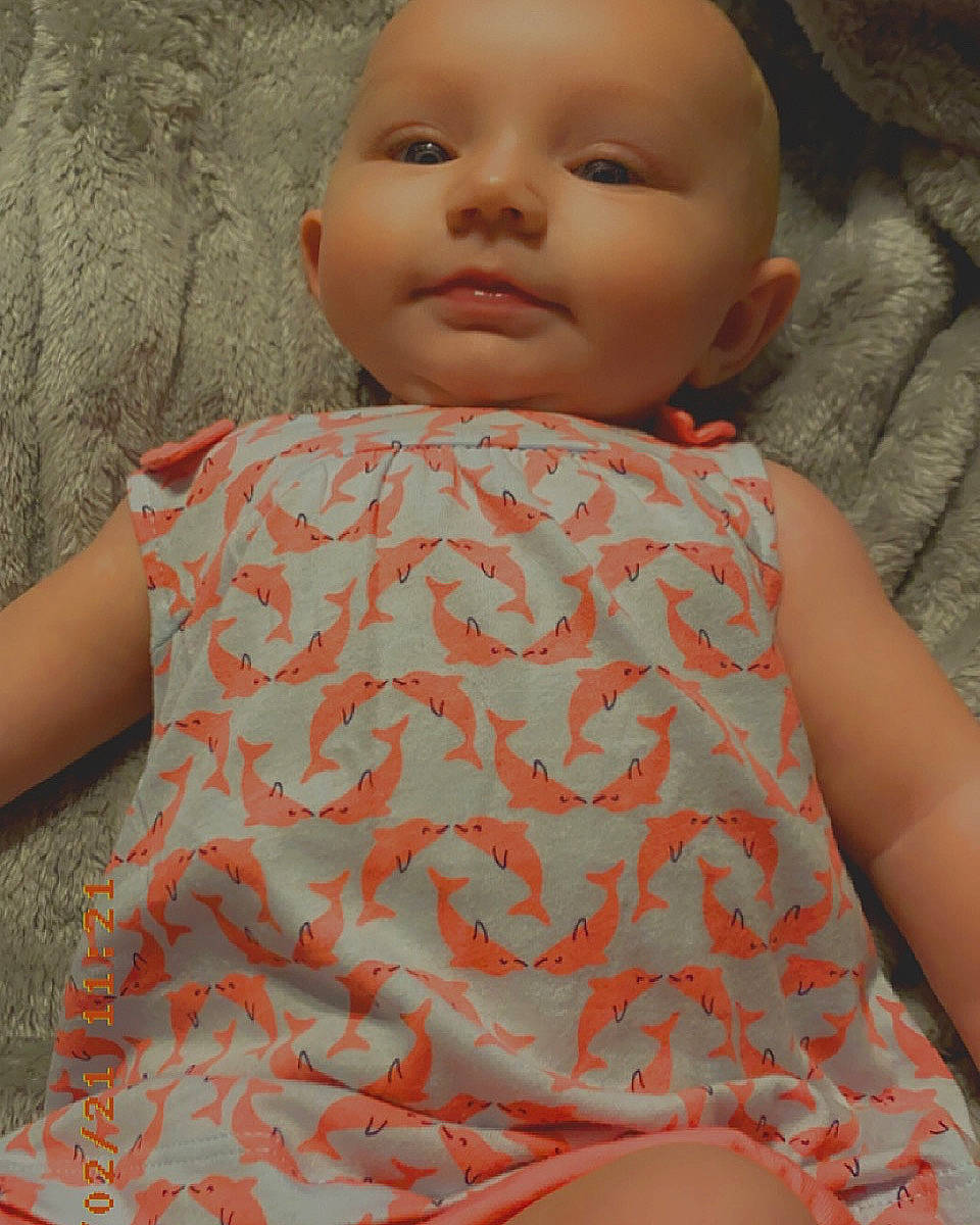 Marceline is registered to the contest to win money with this photo: baby_toddler_clothing, cheek, chin, dress, eye, eyelash, fashion, head, human_body, iris, joint, lip, muscle, neck, nose, orange, organ, person, skin, sleeve